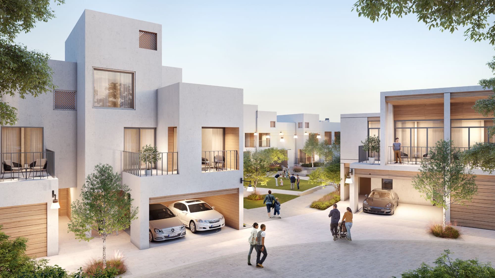 Bliss townhouses in Arabian Ranches 3, Dubai, showing the dark-tone façade and rear-lane garage parking along a landscaped street.